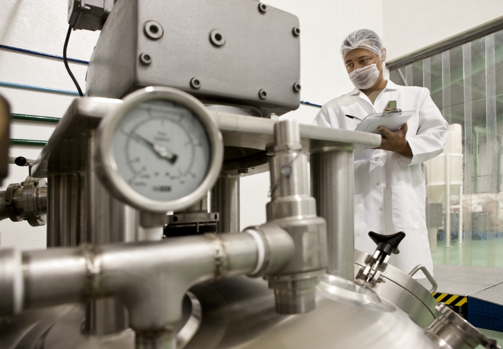 food safety worker in all white working on machine