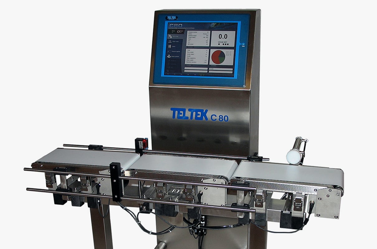 Three-quarter view of a stainless steel Checkweigher with a large digital screen and small conveyor belt.