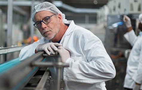 Fließbandarbeiter an einem Cassel Inspektionsgerät in einer Fabrik